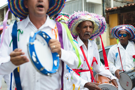 Saubara, Bahia, Brazil - August 03, 2019: Men, women and children, members of the cultural group CheganÃ§a dos Marujos, dance and sing in costumes during a performance at the streets of Saubara, Bahia.のeditorial素材