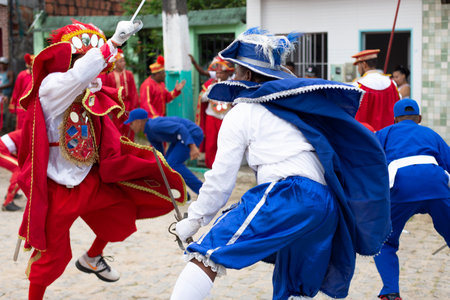 Saubara, Bahia, Brazil - August 03, 2019: Men, women and children, members of the cultural group CheganÃ§a dos Marujos, dance and sing in costumes during a performance at the streets of Saubara, Bahia.のeditorial素材