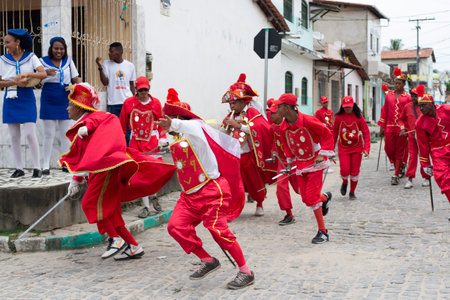 Saubara, Bahia, Brazil - August 03, 2019: Men, women and children, members of the cultural group CheganÃ§a dos Marujos, dance and sing in costumes during a performance at the streets of Saubara, Bahia.のeditorial素材