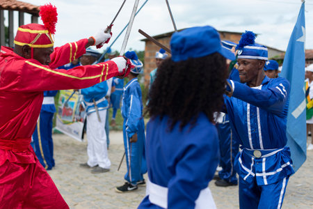 Saubara, Bahia, Brazil - August 03, 2019: Men, women and children, members of the cultural group CheganÃ§a dos Marujos, dance and sing in costumes during a performance at the streets of Saubara, Bahia.のeditorial素材