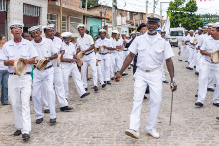 Saubara, Bahia, Brazil - August 03, 2019: Men, members of the cultural group CheganÃ§a dos Marujos, dance and sing in costumes during a performance at the streets of Saubara, Bahia.のeditorial素材