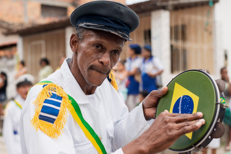 Saubara, Bahia, Brazil - August 03, 2019: Men, women and children, members of the cultural group CheganÃ§a dos Marujos, dance and sing in costumes during a performance at the streets of Saubara, Bahia.のeditorial素材