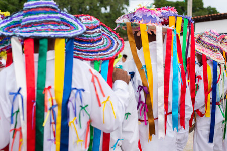 Saubara, Bahia, Brazil - August 03, 2019: Men, women and children, members of the cultural group CheganÃ§a dos Marujos, dance and sing in costumes during a performance at the streets of Saubara, Bahia.のeditorial素材