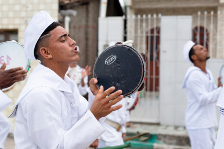 Saubara, Bahia, Brazil - August 03, 2019: Men, women and children, members of the cultural group CheganÃ§a dos Marujos, dance and sing in costumes during a performance at the streets of Saubara, Bahia.のeditorial素材