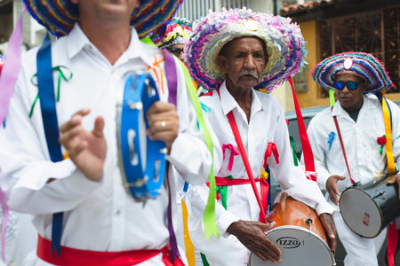 Saubara, Bahia, Brazil - August 03, 2019: Men, women and children, members of the cultural group CheganÃ§a dos Marujos, dance and sing in costumes during a performance at the streets of Saubara, Bahia.のeditorial素材