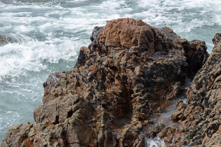 The sea beach and the rocks are polluted with oil. Crude oil spill in northeast Brazil has affected the environment. Rio Vermelho Beach, Salvador, Brazil.の写真素材