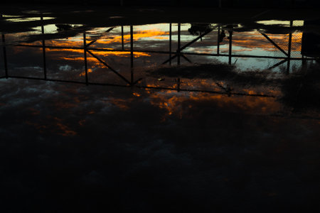 Silhouette of a sport court wet from the rain against dramatic sunset. Sunset after heavy rain....