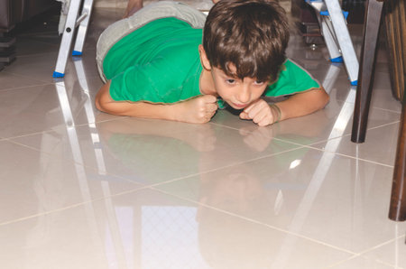 Portrait of a child playing downstairs on a ladder. Skill at home. Salvador, Bahia, Brazil.の写真素材