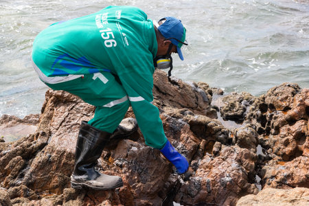 Salvador, Bahia, Brazil - November 03, 2019: Cleaning agents extract oil from Rio Vermelho beach in the city of Salvador. The site was affected by an oil spill off the coast of Bahia.のeditorial素材