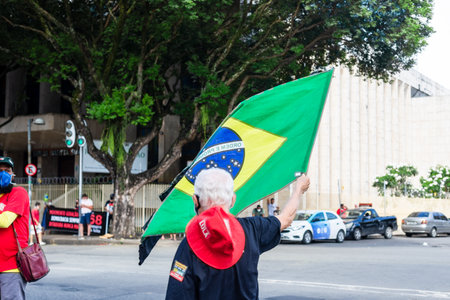 Salvador, Bahia, Brazil - November 20, 2021: Brazilians protest waving flags against the government of President Jair Bolsonaro in the city of Salvador, Bahia.のeditorial素材