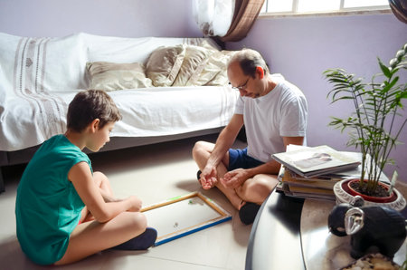 Father and child son playing glazing balls at home. Happy home concept. Salvador, Bahia, Brazil.の写真素材