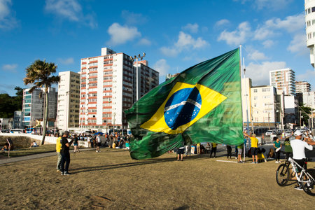 Salvador, Bahia, Brazil - October 22, 2022: Supporters of the President of Brazil Jair Bolsonaro, protest by placing a large Brazilian flag in Farol da Barra square in Salvador.のeditorial素材