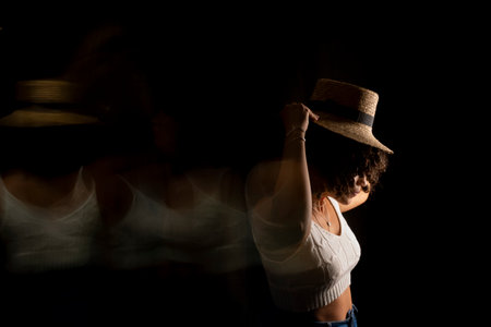 Time-lapse view of woman moving a hat. Long exposure, motion blur. Happy woman. Salvador, Brazil.