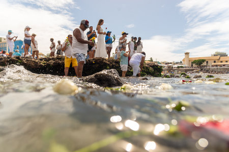 Salvador, Bahia, Brazil - February 02, 2023: People on top of a rock offering gifts to Iemanja at Rio Vermelho beach in Salvador.のeditorial素材