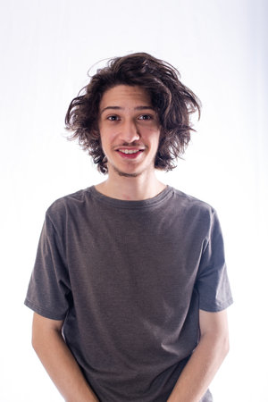 Handsome and cheerful young man smiling looking at camera. Isolated white background.