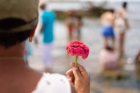 Salvador, Bahia, Brazil - February 02, 2023: Believers of the Camdonble religion are holding flowers...