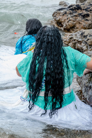 Salvador, Bahia, Brazil - February 02, 2017: Two Candomble women are seen bathing in the sea during the religious festival of Iemanja in Salvador, Bahia.の写真素材