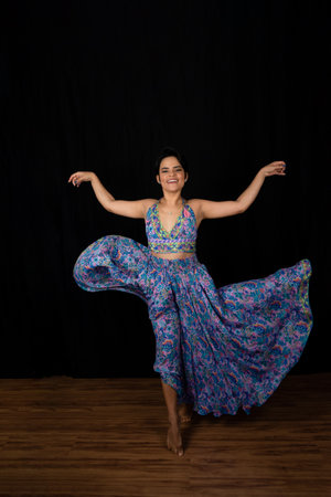 Portrait young woman dancing in studio. Isolated on black background.の写真素材