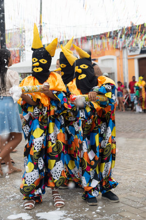 Maragogipe, Bahia, Brazil - February 20, 2023: Three people dressed as grimaces from Maragogipe are seen during Carnival in Bahia, Brazil.のeditorial素材