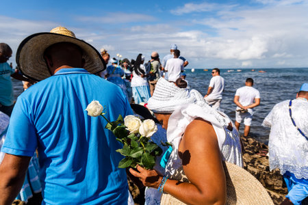 Salvador, Bahia, Brazil - February 02, 2023: Candomble people stand on top of the rocks at Rio Vermelho beach, offering gifts to Yemanja, in Salvador, Bahia.のeditorial素材