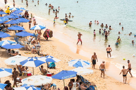 Salvador, Bahia, Brazil - January 14, 2022: Hundreds of people and tourists having fun on Porto da Barra beach under strong sun in Salvador, Bahia.のeditorial素材