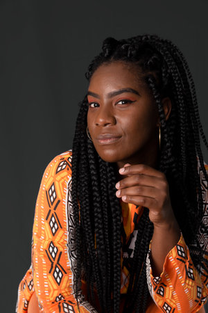 Portrait of serious, beautiful woman wearing colorful outfit. Isolated on gray background.の写真素材