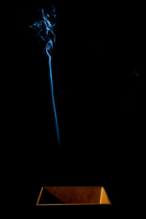 Moving smoke coming out of a wooden box. Isolated on black background.の写真素材