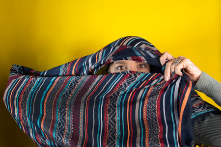 Woman wearing hijab. Isolated on yellow background.の写真素材