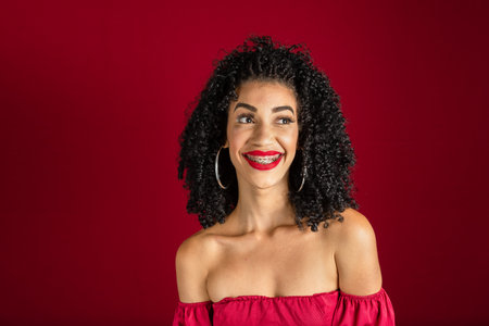 Beautiful and calm woman, standing, posing for the photo. Isolated red background.の写真素材