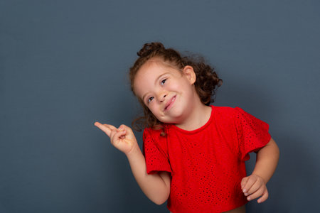 Beautiful and happy girl making hand gestures. Isolated on gray background.の写真素材