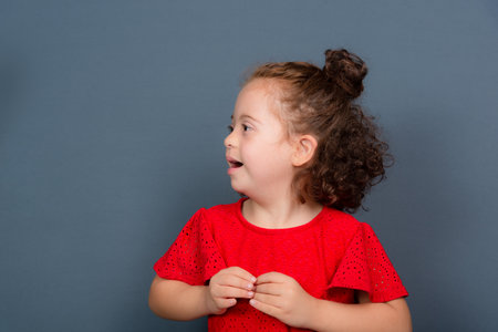 Beautiful and happy girl making gestures with both hands. Isolated on gray background.の写真素材
