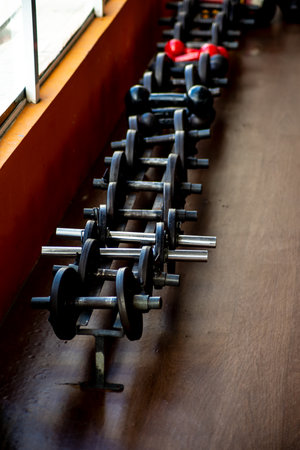Dumbbell arranged in a row in the gym. Iron material, heavy.の写真素材