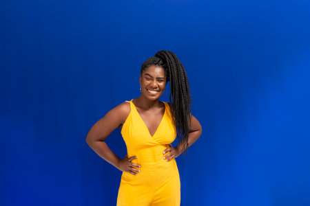 Portrait of beautiful young woman smiling at camera. Isolated on blue background.の写真素材