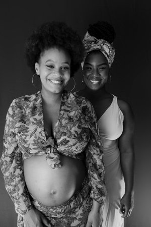 Black and white portrait of two women, friends, one of them is pregnant. Friendship concept.の写真素材