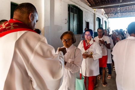 Salvador, Bahia, Brazil - April 07, 2023: Catholic faithful receiving a host during the Mass of the Passion of Christ in the city of Valenca, Bahia.のeditorial素材