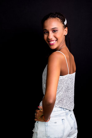 Portrait of teenage girl, smiling, beautiful, wearing white clothes. Isolated on black background.