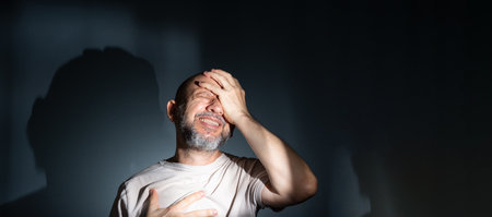 Sad man suffering from headache or migraine. Stressed guy with painful facial expression feeling...