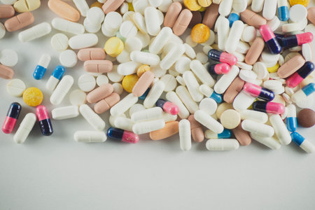 Several pills of different colors laid out on a light gray surface. Medical supplies.の写真素材