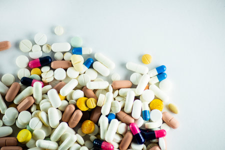 Several pills of different colors laid out on a light gray surface. Medical supplies.の写真素材