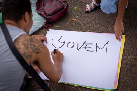 Salvador, Bahia, Brazil - October 29, 2022: Young people are seen writing protest posters for the...