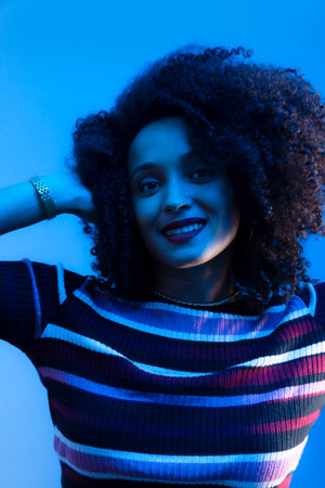 Close-up portrait of a beautiful young woman making hand gestures. Isolated on blue background.