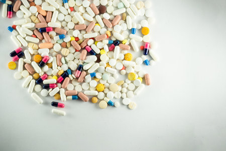 Several pills of different colors laid out on a light gray surface. Medical supplies.の写真素材
