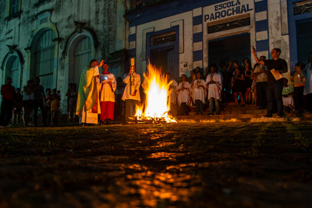 Valenca, Bahia, Brazil - April 08, 2023: Catholic priest is celebrating night mass around the holy bonfire on hallelujah saturday night. Holy week in Valenca, Bahia.のeditorial素材
