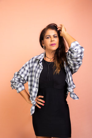 Beautiful attractive woman wearing black outfit and checkered blouse standing posing for the photo....