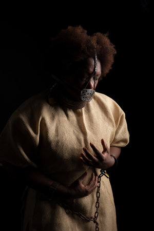 Portrait of a black woman wearing an iron mask on her face to represent the pain of the slave Anastacia. Slavery in Brazil.の写真素材