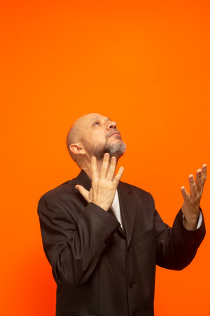 Man in suit jacket, bearded and bald looking up and making gestures. stress at workの写真素材