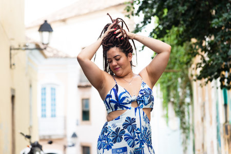 Portrait of a beautiful woman standing on the street posing for photography. Tourist on trip. Pelourinho, Brazil.の写真素材