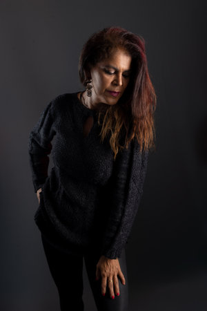 Beautiful and attractive woman wearing black outfit. studio photo. Isolated on dark gray background.の写真素材