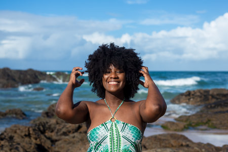Portrait of beautiful woman messing with black power hair smiling confident and happy. In the...