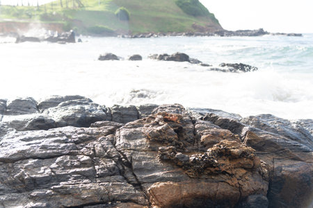 Sea waves breaking hard on the black rocks of the beach. Feeling of relaxation and freedom